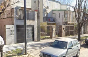 Hombre a bordo de un monopatín balea el frente de una casa en Barrio Acindar.