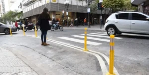 Operarios municipales pintan la señal de PARE en una esquina de Rosario